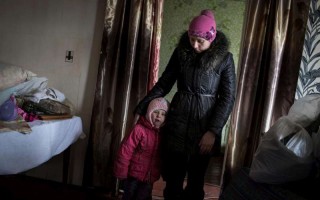 Katia et sa fille, Sofia, rentrent chez elles après avoir reçu des articles de secours de la part du HCR dans l'est de l'Ukraine, le 1er mars 2015.