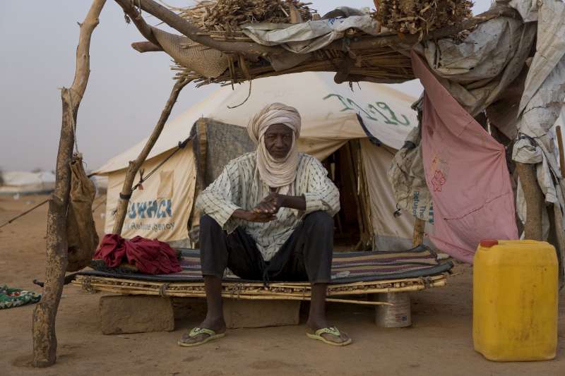 Alassane Maïga est un réfugié malien. Il est assis sur un lit dans le camp de réfugiés d'Abala au Niger.