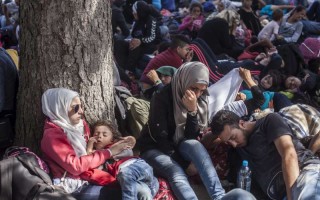 Un groupe de demandeurs d'asile fait une pause durant le voyage à pied à la gare de Tovarnik, en Croatie.