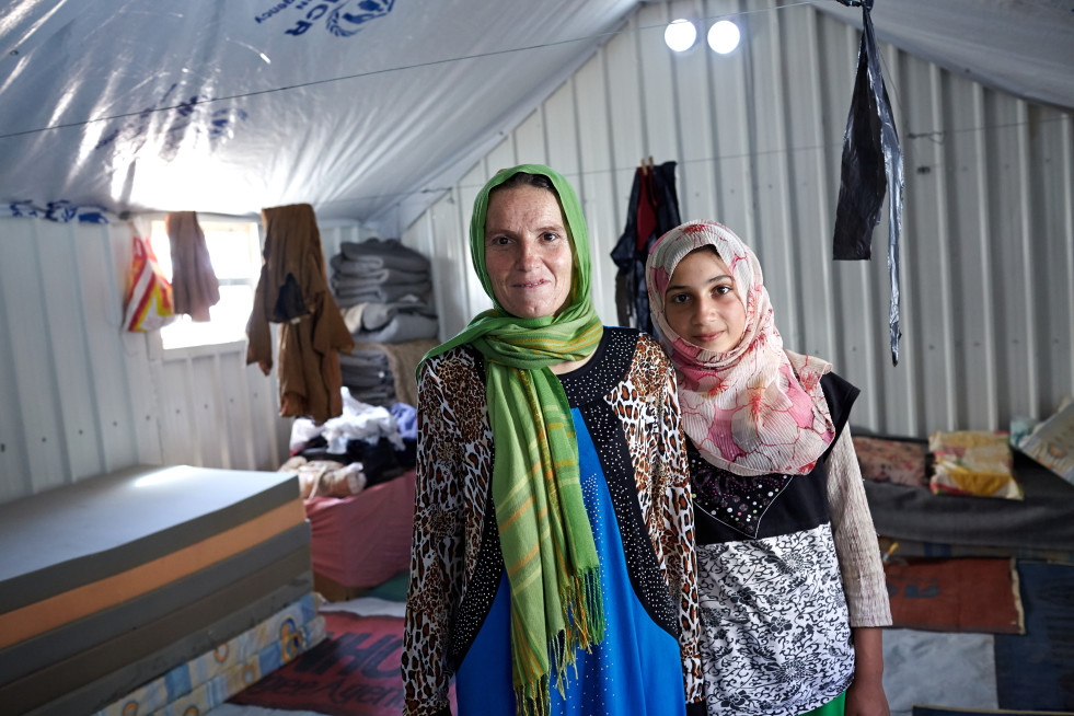 Syrian refugee Mona poses for a photograph with her daughter Bushra in their shelter at the Azraq refugee camp in Azraq, Jordan.