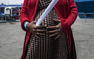 Jamila resting on the docks at Catania's port, Sicily, having been rescued at sea by the Swedish coast guard. She is seven months pregnant. Jamila doesn't know where her baby will be born.