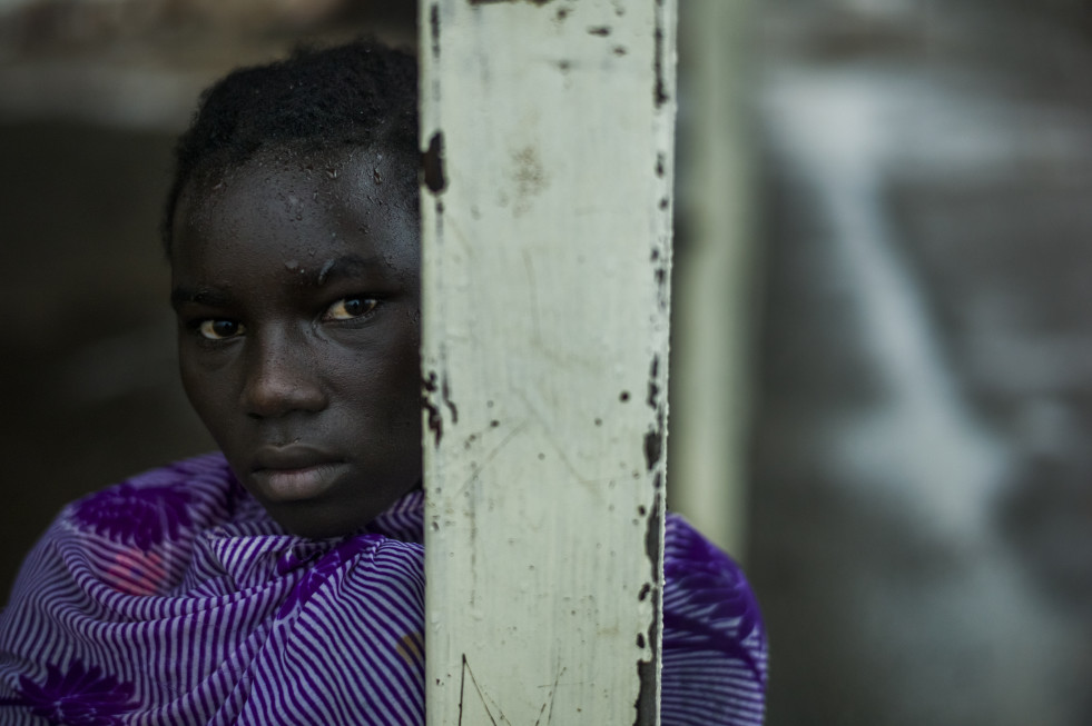 A young refugee waits, cold and wet, for a World Food Program distribution to begin in Kakuma refugee camp days before World Refugee Day, June 20th 2015.