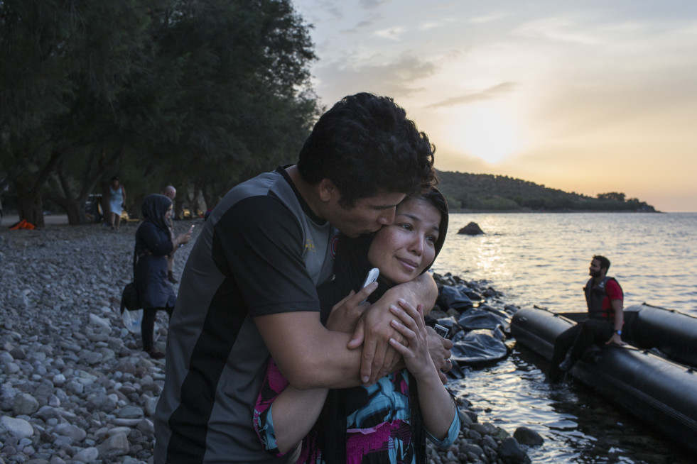 An Afghan man kisses his wife after she was crying while speaking with relatives to tell them they had arrived safely on the Greek island of Lesvos.