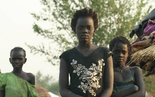 Yayo Tanhko (centre), with her sister Yotok to her left. The two girls looked after their younger siblings in Uganda