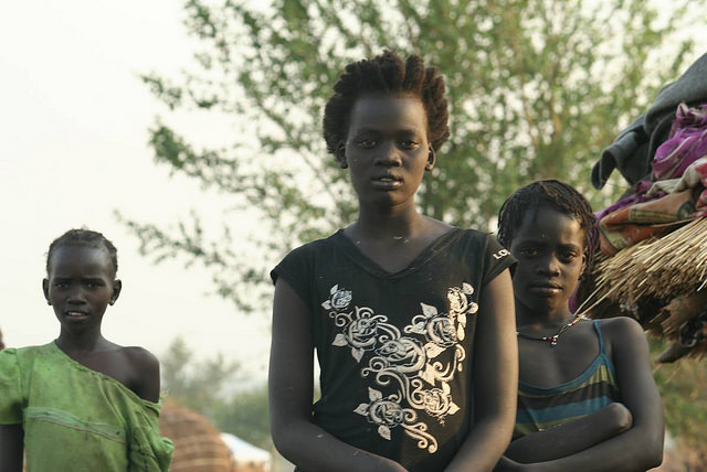 Yayo Tanhko (centre), with her sister Yotok to her left. The two girls looked after their younger siblings in Uganda