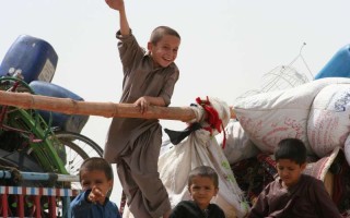 Young Afghan refugees on their way home to Afghanistan wave goodbye to Pakistan.