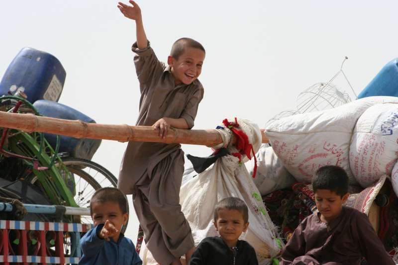 Young Afghan refugees on their way home to Afghanistan wave goodbye to Pakistan. 