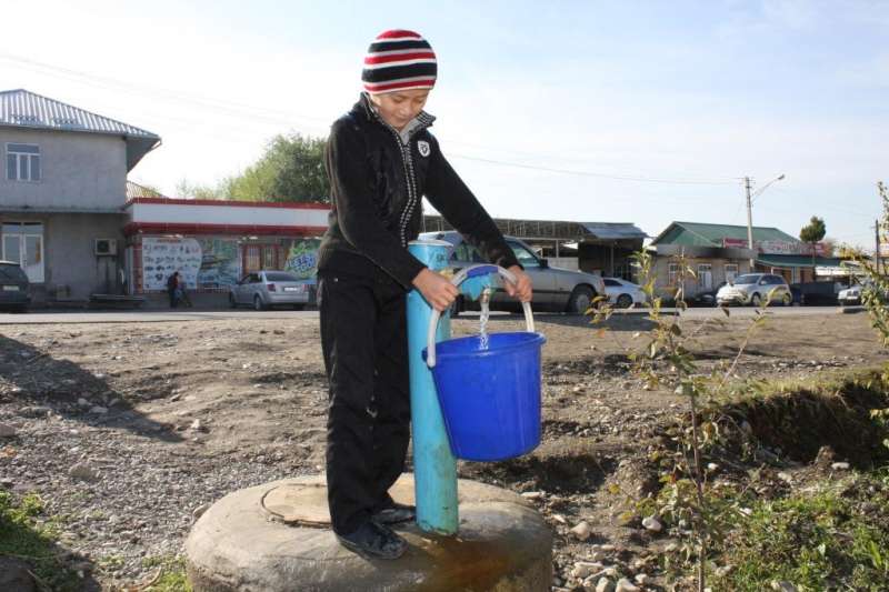 Usmanov Abdulaziz, 12, fills a bucket with drinking water from a standpipe in Tashtak, Kyrgyzstan.