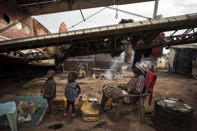 Une famille déplacée trouve refuge sous l'aile d'un vieil aéronef à l'aéroport de Bangui, en République centrafricaine.