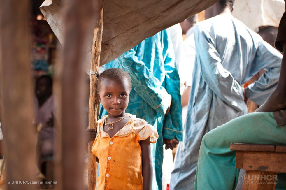 A refugee girl from the Central African Republic at the Mbile site in Cameroon walks through the market on 9 January 2015