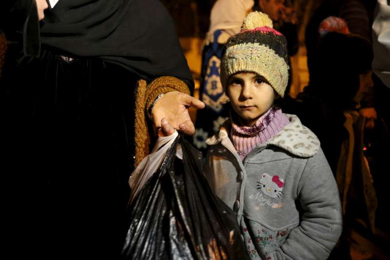 A Syrian girl waits with her family to leave the besieged Syrian town of Madaya, January 11, 2016.
