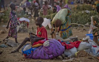 A young South Sudanese boy sits on a bundle of clothes at Dzaipi Reception Centre in northern Uganda.
