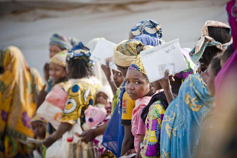 Des réfugiés centrafricains, y compris des mères et de jeunes enfants, sur le site de Timangolo au Cameroun dans une file d'attente pour recevoir de la nourriture.