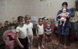 Nina est une déplacée ukrainienne. Mère célibataire, elle pose avec ses cinq enfants après leur retour de l'école.