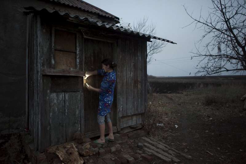 Nina stands beside the old family home which she abandoned after repeated artillery barrages.