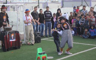 A performer with Clowns Without Borders entertains children at Kawergosk Refugee Camp, in Iraq's norther Kurdistan region.