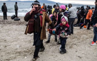 A family of refugees walk along the beach after landing on the Greek island of Lesvos in January 2016.