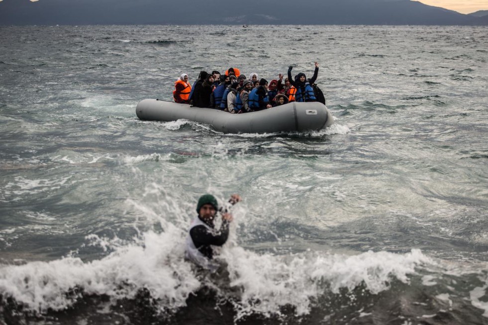 A volunteer battles the waves as a boatload of refugees arrives at the Greek island of Lesvos. UNHCR/Hereward Holland