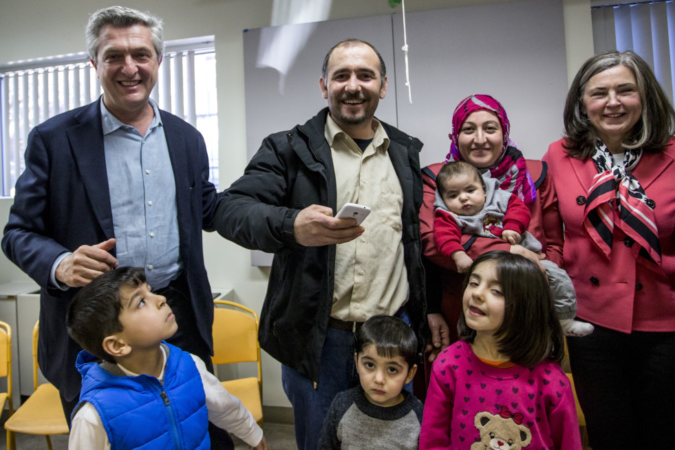 High Commissioner Filippo Grandi and IRCC Deputy Minister Anita Bigus greet the Halo Family at the Head Office of the Catholic Centre for Immigrants in downtown Ottawa. From left to right: High Commissioner Filippo Grandi, Ferhan Halo, Malva Halo holding baby Sehmus, Deputy Minister Anita Bigus and the Halo children. @ UNHCR/G. Capriotti
