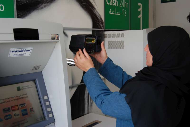 A Syrian refugee scans her iris at a branch of Cairo Amman Bank in the Jordanian capital. Jordan is the first country in the world to use iris scan technology to enable refugees to access monthly cash assistance provided by UNHCR. Around 23,000 Syrian families living in urban areas in Jordan benefit from monthly cash assistance. © UNHCR Photo