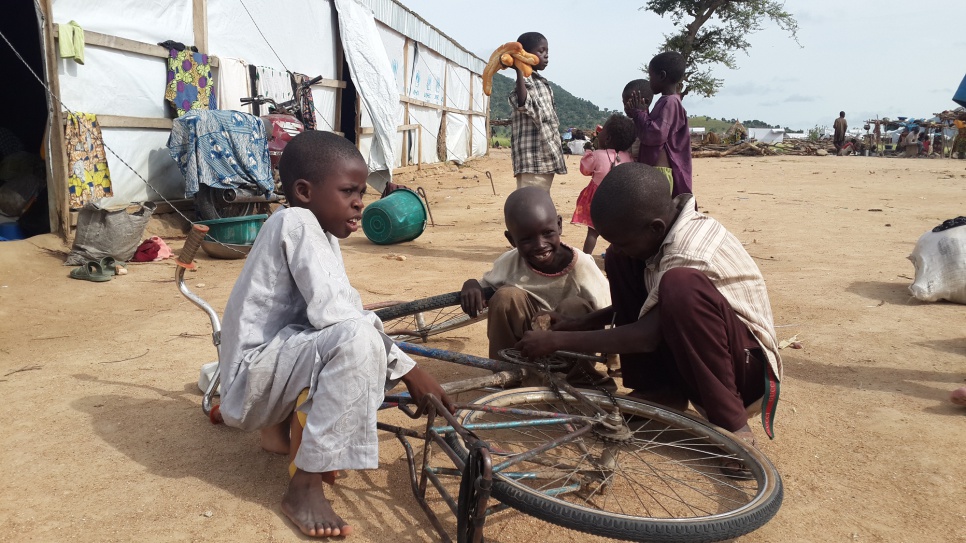 Refugee children repair a bicycle at Minawao camp in Cameroon, 2015 file photo. © UNHCR/D. Mbaiorem