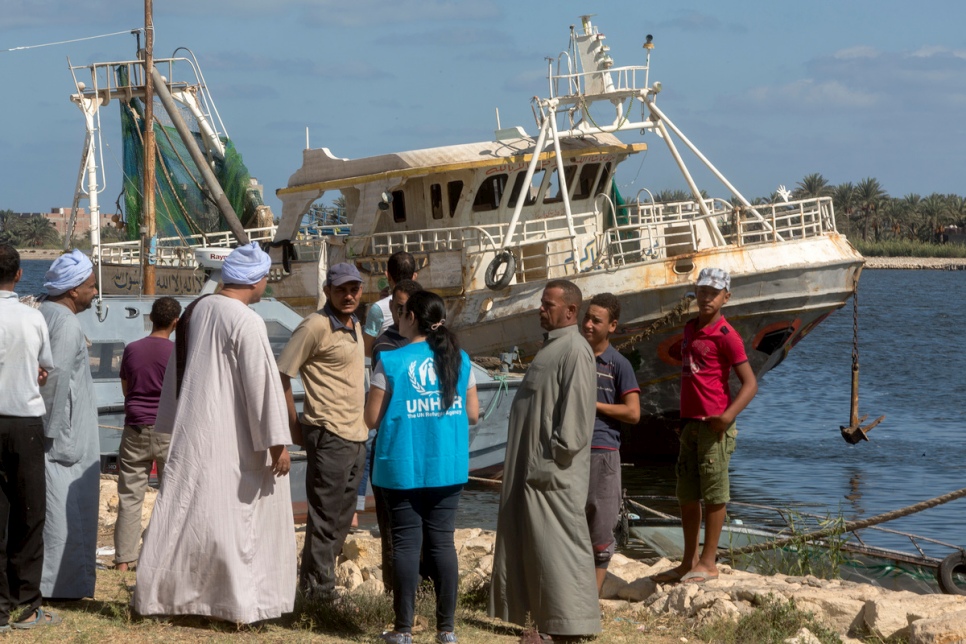 A UNHCR staff member talks with Egyptian fishermen near the retrieved wreckage of an Egyptian fishing boat in Rashid, Egypt, on September 28, 2016. © UNHCR/Scott Nelson