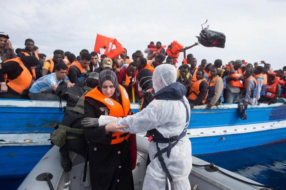 People trying to cross from north Africa to Europe on an overloaded fishing boat are rescued from the Mediterranean Sea by the Italian Navy, June 5, 2014. © Massimo Sestini for the Italian Navy