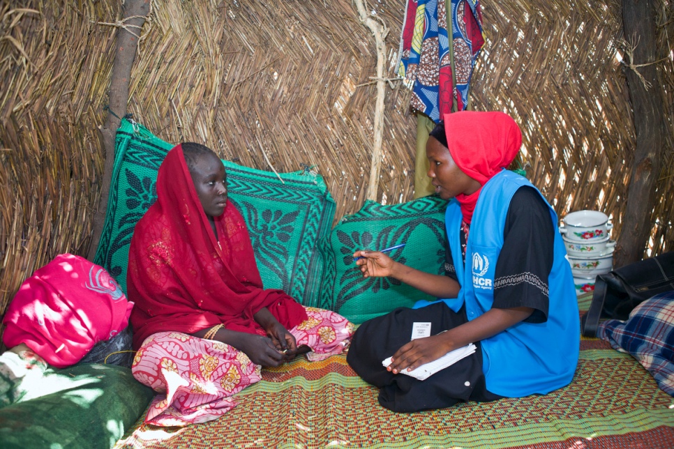A UNHCR staff member takes notes during a conversation with a displaced woman at Kuya camp, in Monguno, Nigeria. Women head many of the families there because their husbands have been killed by Boko Haram or have disappeared. © UNHCR/Hélène Caux