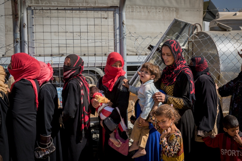 Displaced Iraqi women line up to receive food and water at Debaga camp for internally displaced people in Iraq’s Erbil Governorate. © UNHCR/Ivor Prickett
