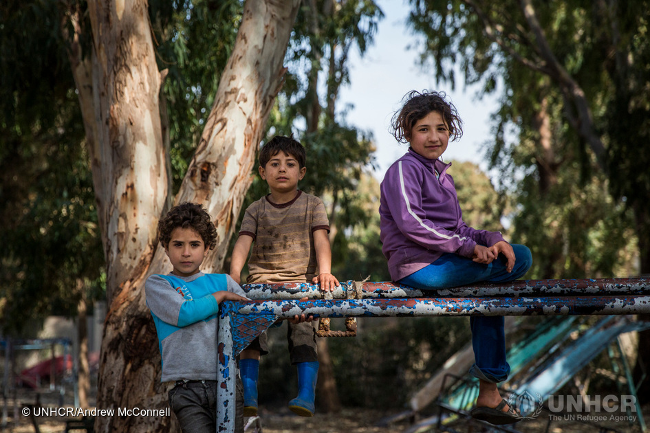 Siblings from Aleppo, Aminah, 10, Hussein, 4, and Aya,12, play in an old playground in the Pioneer Camp for internally displaced persons in Tartous, Syria. 