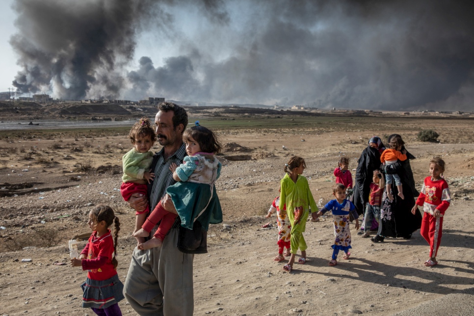 An Iraqi family displaced by fighting in the village of Shora walks towards an Iraqi army checkpoint near Qayyarah. © UNHCR/Ivor Prickett