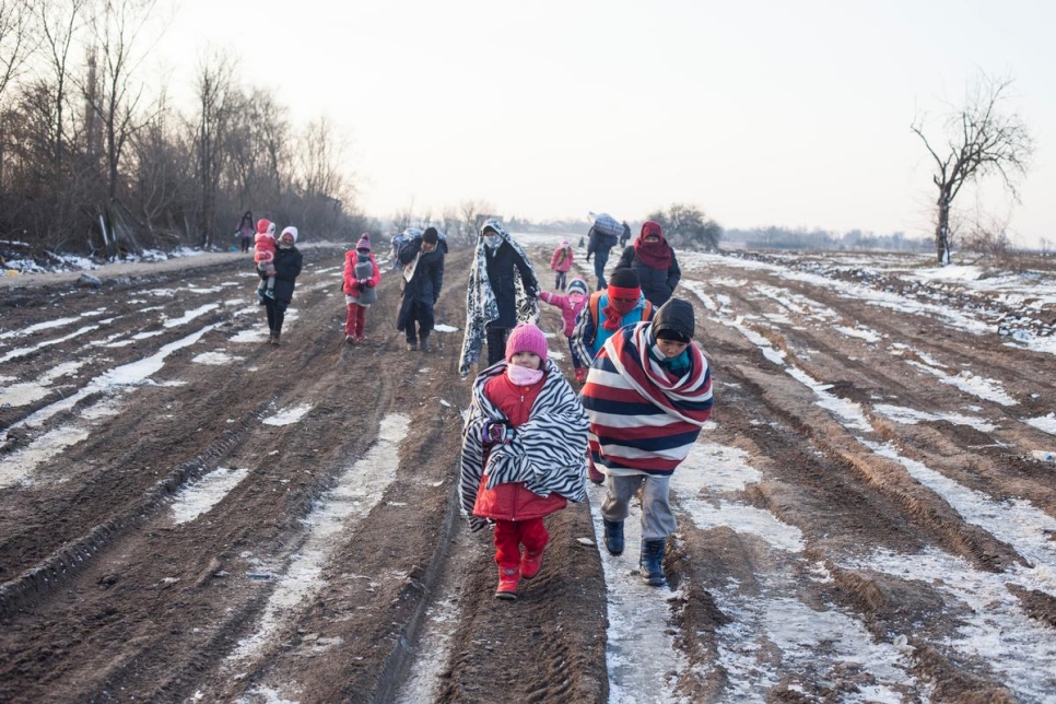 Refugees wrapped in blankets and winter clothing cross the Macedonia-Serbia border in freezing temperatures in this January 2016 file photo. © UNHCR/Igor Pavicevic
