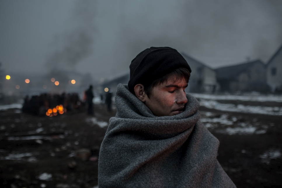 Hazrat, 16, an Afghan refugee, warms himself at a fire behind the main train station of Belgrade. © UNHCR/Daniel Etter