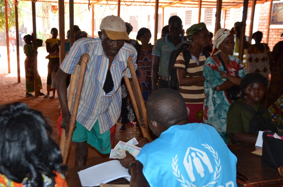 Antoine Nambeyam receives a cash grant from UNHCR to help him settle back into his home in Bangui, the capital of the Central African Republic. © UNHCR/Djerassem Mbaiorem