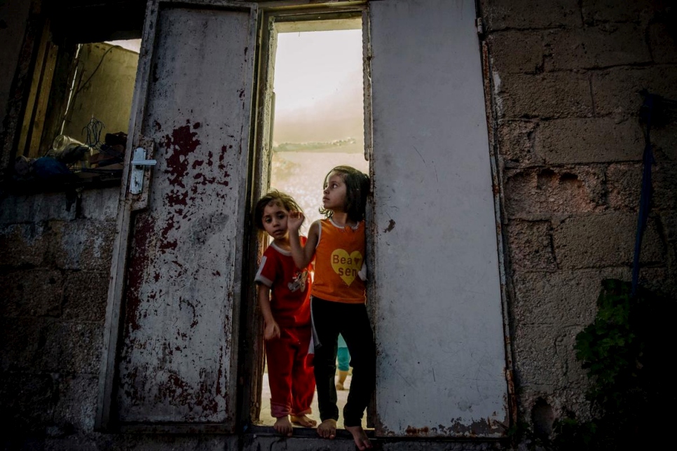 Syrian refugee Mais, and her younger sister Anaghem, stand at the door of their apartment in Amman, Jordan, in this 2014 file photo. © UNHCR/J. Kohler