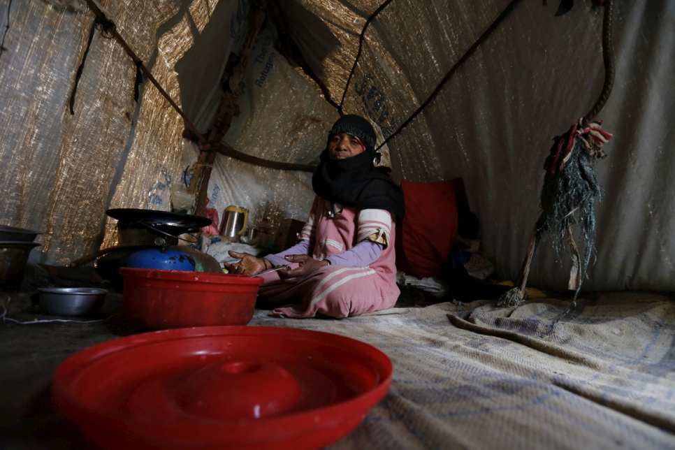 Zahrah, a widow and mother of eight displaced by war, sits in a makeshift shelter in Sana’a, Yemen. © UNHCR/Mohammed Hamoud