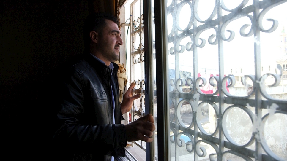 Syrian refugee Firas al Ahmad, 30, looks out of the window at his father’s house in Irbid, Jordan, the day before he left for the United States. © UNHCR/Houssam Hariri