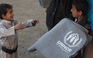 refugee child receiving blanket
