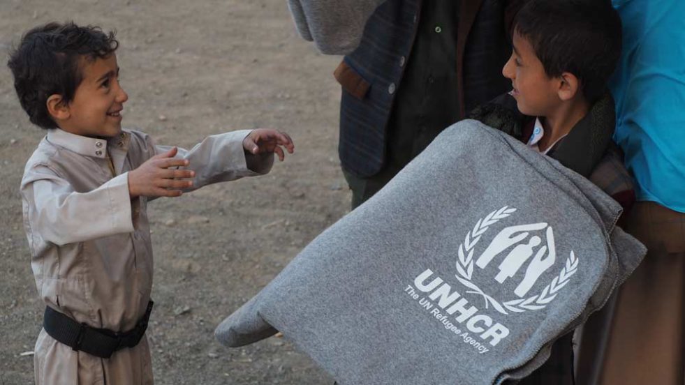 refugee child receiving blanket