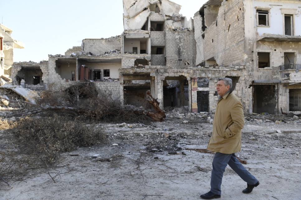 U.N. High Commissioner for Refugees Filippo Grandi walks past badly damaged buildings in the Karm Al-Myassar neighbourhood in eastern Aleppo during a visit in February 2017. © UNHCR/Bassam Diab