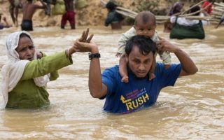 Une famille de réfugiés rohingyastraversant une rivière