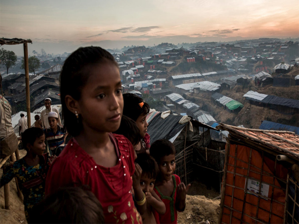 Young Rohingya refugees look out over Palong Khali refugee camp, a sprawling site located on a hilly area near the Myanmar border in southeast Bangladesh. © UNHCR/Andrew McConnell