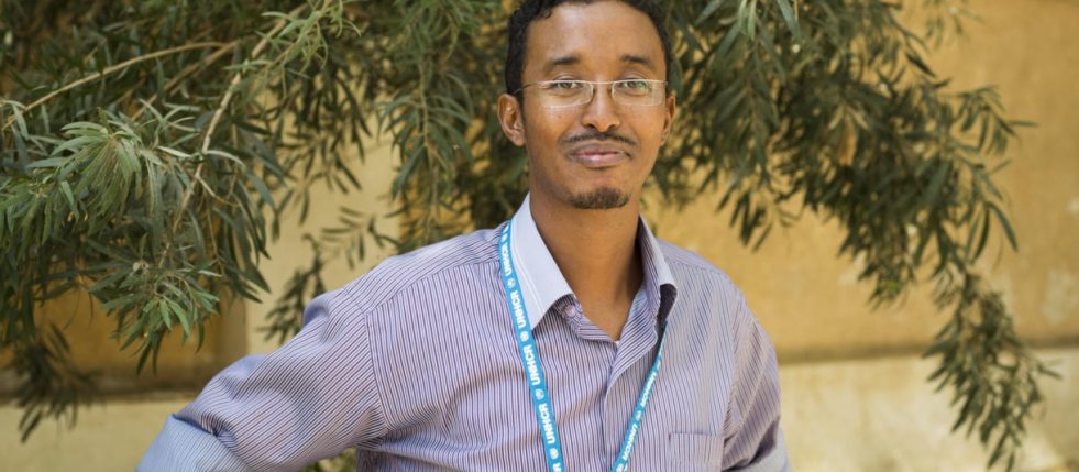 man wearing glasses standing posed with slight close-lipped smile