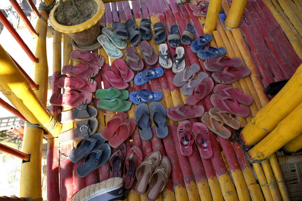 Several pairs of colourful sandals arranged in a circle on a colourful bamboo patio