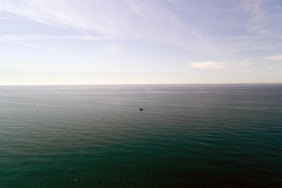 A boat floats alone on the Mediterranean