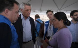 Filippo Grandi listens to Venezuelan woman in a crowded room