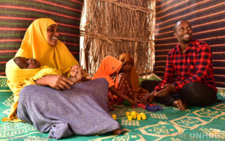 A Somali family sits on the floor of their house