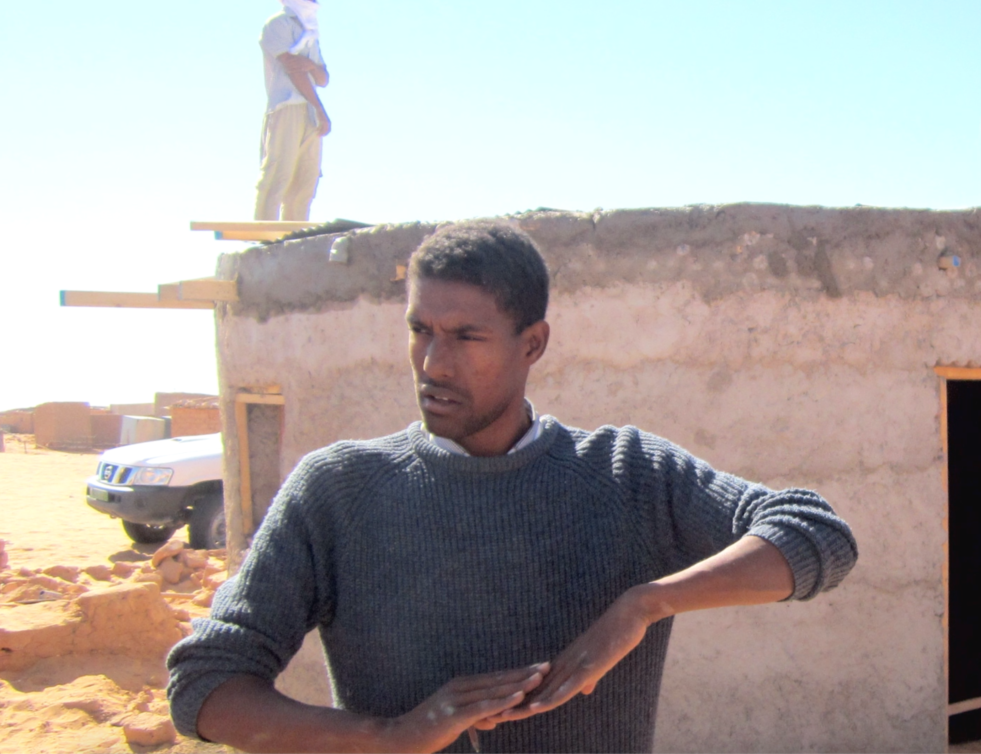 A portrait of a man who recycles plastic bottles to make houses