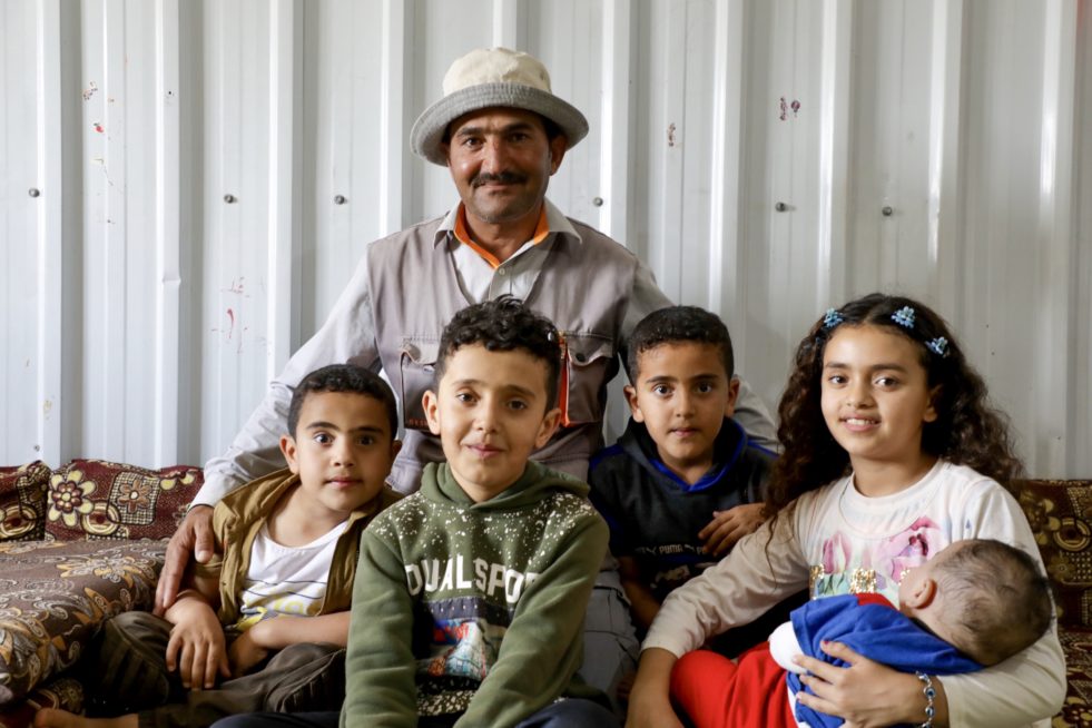 A refugee man poses with his four children