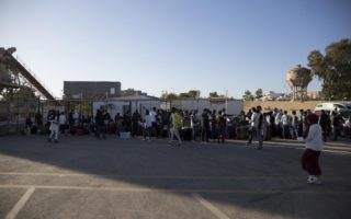A crowd of refugees wait to board a bus as they are evacuated from Libya